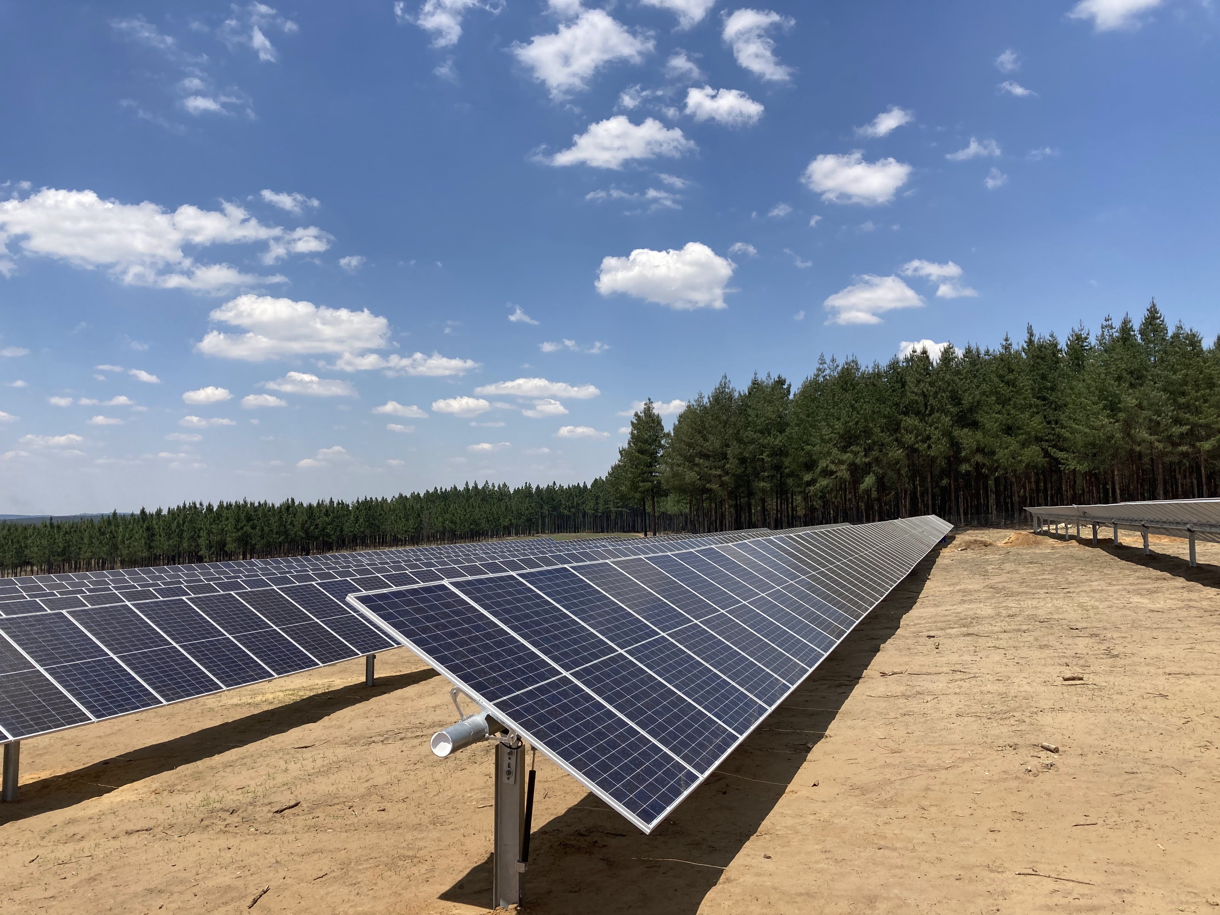 Utility-scale ground-mounted solar array on a remote site, typical of mining baseload supply projects